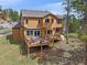 Backyard view of a multi-level deck, mature trees, and beautiful surrounding landscape at 3173 Gold Yarrow Ln, Evergreen, CO 80439