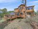Backyard view of a multi-level deck, mature trees, and beautiful surrounding landscape at 3173 Gold Yarrow Ln, Evergreen, CO 80439
