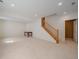 Spacious basement area with neutral carpet, wooden staircase, and access to a separate room at 3173 Gold Yarrow Ln, Evergreen, CO 80439