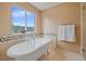 Bright bathroom featuring a soaking tub and a window with a view at 3173 Gold Yarrow Ln, Evergreen, CO 80439