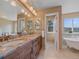 Bathroom featuring double sinks and a soaking tub with bright windows at 3173 Gold Yarrow Ln, Evergreen, CO 80439