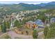 Exterior aerial view of a home on a sloping lot with trees and mountain views at 3173 Gold Yarrow Ln, Evergreen, CO 80439