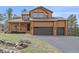 Inviting exterior showcasing a covered porch and two-car garage at 3173 Gold Yarrow Ln, Evergreen, CO 80439