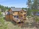 Back of house features a large wooden deck, ideal for outdoor living and entertaining at 3173 Gold Yarrow Ln, Evergreen, CO 80439