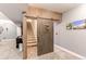 Finished basement with rustic sliding barn door leading to the carpeted stairwell at 25120 E Maple Pl, Aurora, CO 80018