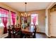 Formal dining room featuring a wooden table, chandelier lighting, and bright windows with curtains at 25120 E Maple Pl, Aurora, CO 80018