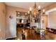 Elegant dining room with a large wooden table, decorative chandelier, and open access to kitchen at 25120 E Maple Pl, Aurora, CO 80018