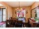 Charming dining room with a large wood table, elegant chandelier, and natural light from windows at 25120 E Maple Pl, Aurora, CO 80018