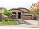 Charming home boasts a covered front porch, well-manicured lawn, and an attached two-car garage at 25120 E Maple Pl, Aurora, CO 80018