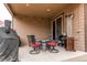 Cozy covered patio area with stylish seating, stone fire pit table, heater, and outdoor lights at 25120 E Maple Pl, Aurora, CO 80018