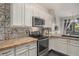 Updated kitchen with stainless steel appliances, white cabinetry, and designer backsplash at 14400 Albrook Dr # 43, Denver, CO 80239