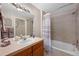 Well-lit bathroom with a tiled shower-tub combo, single sink vanity, and soft, neutral tones at 22610 E Ontario Dr # 204, Aurora, CO 80016