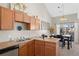 Functional kitchen featuring warm cabinetry, practical layout, and a view of the dining area at 22610 E Ontario Dr # 204, Aurora, CO 80016