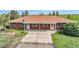 Low aerial view of a ranch-style home with a large driveway and covered front porch at 1614 N Manila Rd, Bennett, CO 80102