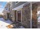 Exterior view of townhouse entrance with stonework and a brown door at 12831 Mayfair Way # F, Englewood, CO 80112