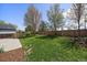 Fenced backyard features a well-maintained lawn, mulch, and trees for privacy and enjoyment at 381 Tynan Dr, Erie, CO 80516