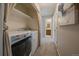 Hallway laundry area with modern washer and dryer, shelves, and view to bathroom at 381 Tynan Dr, Erie, CO 80516