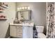 Bright bathroom with white vanity and sink, a large mirror, toilet and a shower behind a curtain at 1560 Olympia Cir # 108, Castle Rock, CO 80104