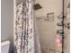 Tiled shower and toilet behind a floral shower curtain with tile flooring at 1560 Olympia Cir # 108, Castle Rock, CO 80104