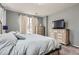 Bedroom featuring soft carpet, bed, two windows, and dresser with television at 1560 Olympia Cir # 108, Castle Rock, CO 80104