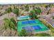 A stunning aerial shot showcasing a pool and tennis courts surrounded by lush greenery and trees at 2590 W Long Cir, Littleton, CO 80120