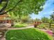 Beautiful backyard with manicured lawns, colorful flowerbeds, and a charming stone pathway at 2590 W Long Cir, Littleton, CO 80120