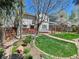 A spacious backyard with a lush lawn, beautiful landscaping, and a patio area for outdoor entertaining at 2590 W Long Cir, Littleton, CO 80120
