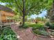 Beautifully landscaped backyard featuring a covered patio, garden, and lush lawn at 2590 W Long Cir, Littleton, CO 80120