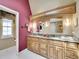 Charming bathroom boasts double sinks, marble counters, decorative mirrors, and stylish lighting at 2590 W Long Cir, Littleton, CO 80120
