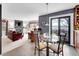 Bright dining area with glass table, sliding doors with neighborhood view, and adjacent kitchen and living room at 2590 W Long Cir, Littleton, CO 80120