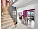 Open-concept entryway leading to a dining area, living room, and a staircase with carpet runner at 2590 W Long Cir, Littleton, CO 80120