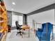 Bright home office with a built-in bookcase, a comfortable chair, and an adjacent seating area at 2590 W Long Cir, Littleton, CO 80120