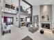 Bright and inviting living room featuring soaring ceilings, a stone fireplace, and stylish modern decor at 2590 W Long Cir, Littleton, CO 80120