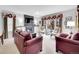 Bright and airy living room showcasing a fireplace, TV, and large windows with floral valances at 2590 W Long Cir, Littleton, CO 80120