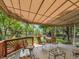 Relaxing covered patio featuring a dining area and comfortable seating surrounded by lush landscaping at 2590 W Long Cir, Littleton, CO 80120