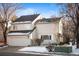 Beige two-story home with attached garage and snow-covered yard at 4530 S Verbena St # 309, Denver, CO 80237