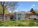 Cozy backyard shed with charming details and a wood pile at 4290 Cottonwood Lakes Blvd, Thornton, CO 80241