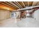 Unfinished basement space with exposed beams, concrete walls, and a staircase at 4290 Cottonwood Lakes Blvd, Thornton, CO 80241