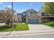 Two story home featuring stone accents and blue siding, with a well manicured lawn at 4290 Cottonwood Lakes Blvd, Thornton, CO 80241