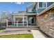 A covered porch with stone siding leads to the front entrance of this two story home at 4290 Cottonwood Lakes Blvd, Thornton, CO 80241