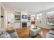 Bright living room with hardwood floors, fireplace, built-in shelves, and open view to the kitchen at 4290 Cottonwood Lakes Blvd, Thornton, CO 80241