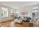 Bright and airy living room featuring hardwood floors, an oversized ottoman, and neutral decor at 4290 Cottonwood Lakes Blvd, Thornton, CO 80241