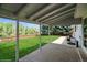 Covered back patio overlooking a spacious lawn and fenced yard, perfect for outdoor relaxation at 7325 S Houstoun Waring Cir, Littleton, CO 80120