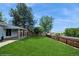 Spacious backyard with a well-maintained lawn, mature trees, and a privacy fence at 7325 S Houstoun Waring Cir, Littleton, CO 80120