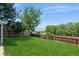 Backyard features a green lawn, wooden fence, and mature trees at 7325 S Houstoun Waring Cir, Littleton, CO 80120