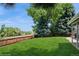 Lush green backyard with a well-maintained lawn, wooden fence, and mature trees at 7325 S Houstoun Waring Cir, Littleton, CO 80120
