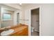 Bathroom featuring wood vanity, vessel sink, medicine cabinet, and toilet in separate area at 7325 S Houstoun Waring Cir, Littleton, CO 80120