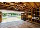Spacious garage with open door, exposed wood beams, built-in shelving, and ample storage at 7325 S Houstoun Waring Cir, Littleton, CO 80120