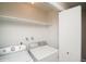 Convenient laundry room features a washer, dryer, and ample shelving space at 7325 S Houstoun Waring Cir, Littleton, CO 80120