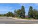 Community street view featuring lush greenery, mature trees, and neighborhood signage at 7325 S Houstoun Waring Cir, Littleton, CO 80120